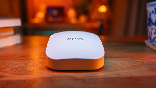 An eero device sitting on a wooden coffee table.
