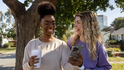 Two friends laughing outdoors.