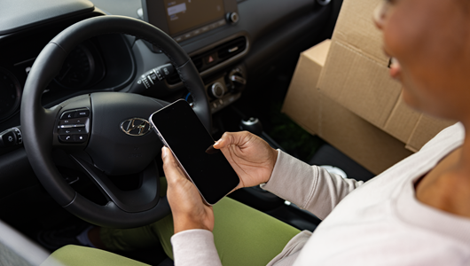 Woman looking at her phone in her car.