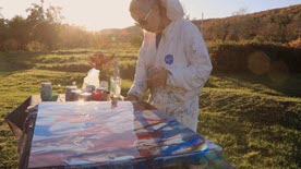 Kristen painting at her home outdoors.